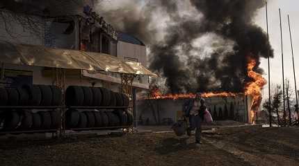 man recovers items from a burning shop