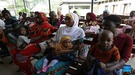 Children wait to be vaccinated against polio