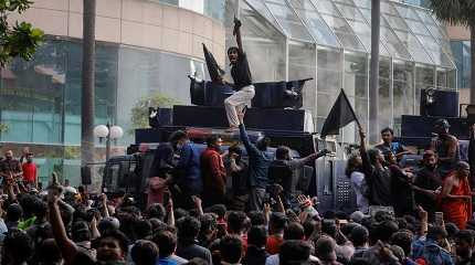 Protestors stand on a water cannon vehicle