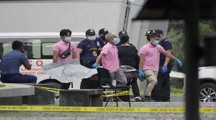 Funeral workers carry a victim's body in Philippines