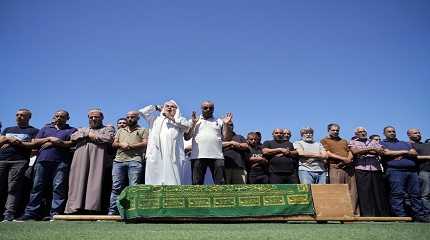 Mourners pray over the coffin of boat carrying migrants