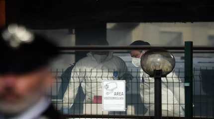 Forensic police officers inspect a bar where three people died