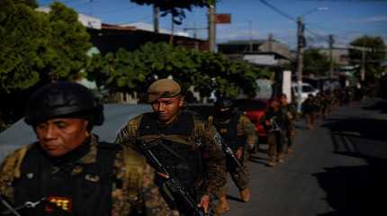 Troops walk in the suburb of Soyapango