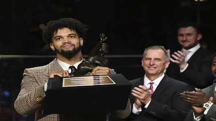 quarterback Caleb Williams holds the Heisman Trophy