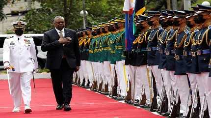 Lloyd Austin III walks past military guards