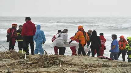 Rescuers recover a body at a beach