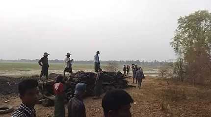 Men stand over a funeral pyre 