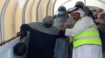 woman evacuated from Sudan is assisted as she arrives in Abu Dhabi airport