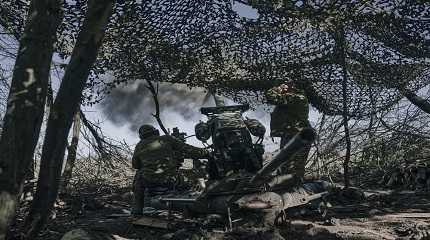 Ukrainian soldiers fire a cannon