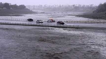 Vehicles cross over a flood