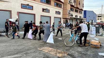 Palestinians carry food supplies