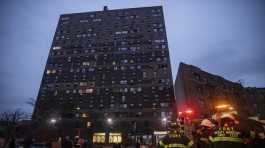 Emergency personnel work at the scene of a fire at Bronx building