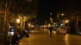 People rest on chairs by a street in Tunis