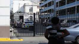 gang members step out of a police truck in Jamaica