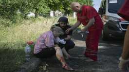 police officer and paramedic give the first aid to a woman