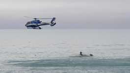 A helicopter flies overs an upturned boat in New Zealand