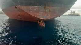 Three stowaway migrants are seen on the rudder blade of petrol vessel