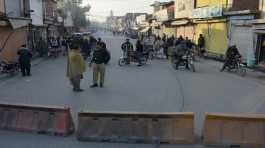 Security officials stand guard on a blocked road