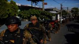 Troops walk in the suburb of Soyapango