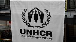 logo is pictured on a banner at the UNHCR