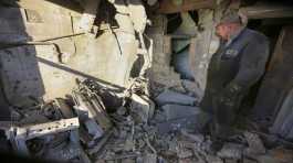 man examines a damaged apartment