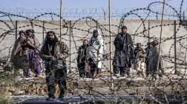 Taliban fighters check the site of an explosion