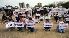 Afghan refugees hold placards during a protest