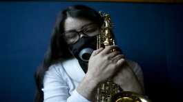 Maria Elena Ríos holds her saxophone