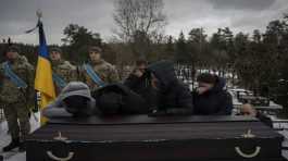 Relatives stand by the coffin