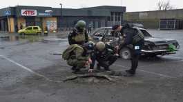 Police investigators inspect a shell