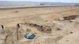 Archaeologists excavate the hull of a wooden ship