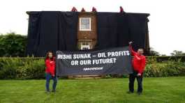 Greenpeace activists hold a banner