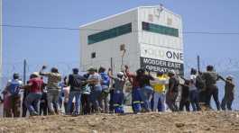 miners gather at the top of a goldmine shaft