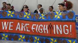 Activists hold a banner